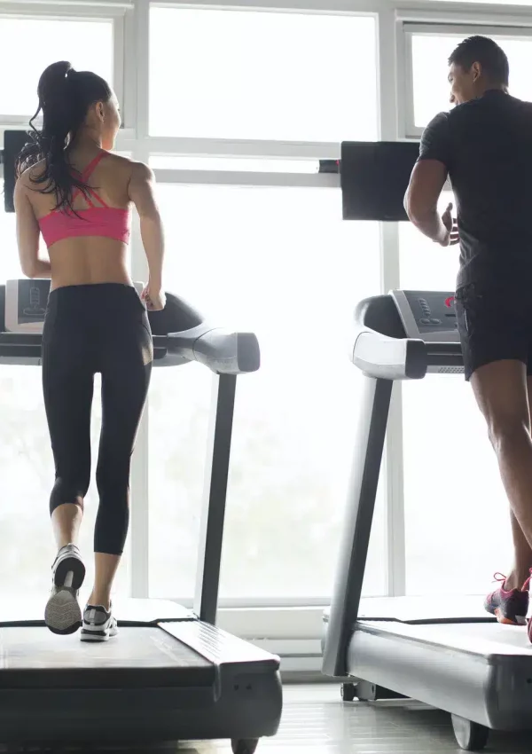 young-couple-exercising-on-treadmills-in-gym.jpg